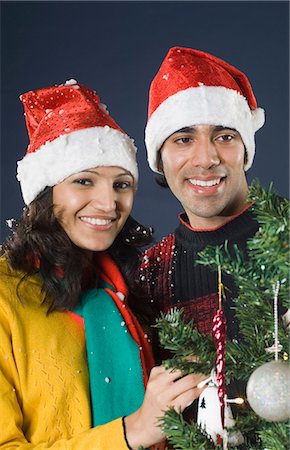 Portrait of a couple decorating a Christmas tree and smiling Stock Photo - Premium Royalty-Free, Code: 630-03480444