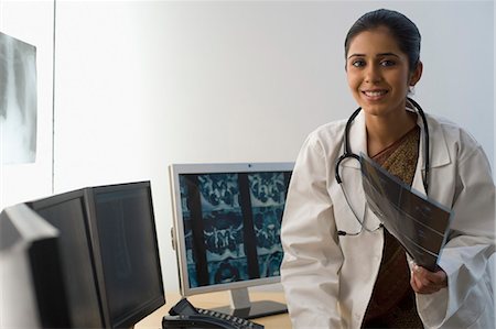 simsearch:630-03480875,k - Portrait of a female doctor holding an X-Ray report and smiling Foto de stock - Sin royalties Premium, Código: 630-03480751