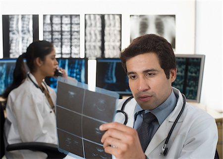 Male doctor examining an X-Ray report Stock Photo - Premium Royalty-Free, Code: 630-03480765