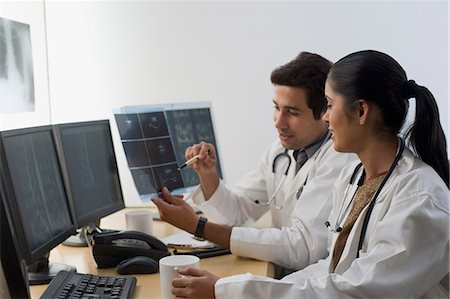 Female doctor with a male doctor examining an X-Ray report Stock Photo - Premium Royalty-Free, Code: 630-03480769