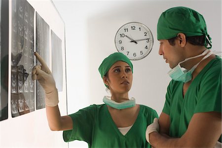 Female surgeon with a male surgeon examining an X-Ray report Stock Photo - Premium Royalty-Free, Code: 630-03480840