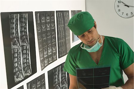 simsearch:630-03481457,k - Male surgeon examining an X-Ray report Foto de stock - Sin royalties Premium, Código: 630-03480857