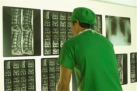 simsearch:630-03481457,k - Male surgeon examining an X-Ray report Foto de stock - Sin royalties Premium, Código: 630-03480861