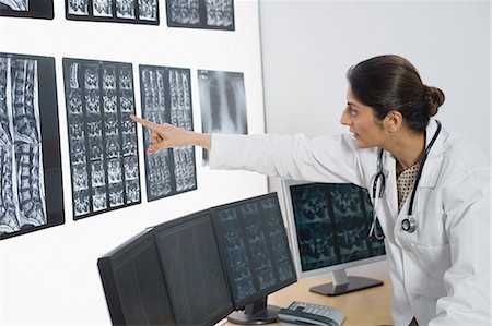 Female doctor examining X-Ray report Stock Photo - Premium Royalty-Free, Code: 630-03480930