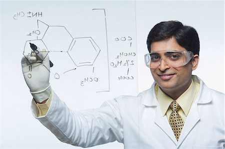 Scientist writing chemical formula Stock Photo - Premium Royalty-Free, Code: 630-03480978