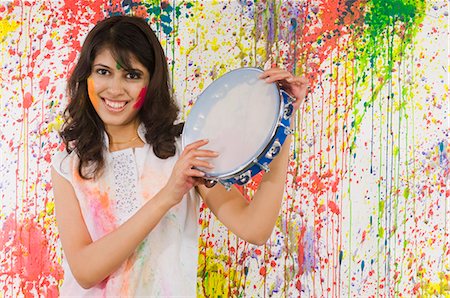 Woman playing tambourine and smiling Stock Photo - Premium Royalty-Free, Code: 630-03481055