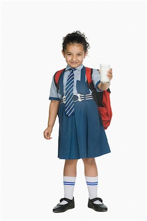 schoolbag - Portrait of a schoolgirl holding a glass of milk and smiling Stock Photo - Premium Royalty-Free, Code: 630-03481149