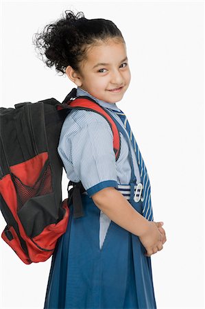 schoolbag - Portrait of a schoolgirl carrying a schoolbag and smiling Stock Photo - Premium Royalty-Free, Code: 630-03481143