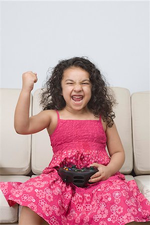 simsearch:6108-06905230,k - Girl playing a video game and looking excited Stock Photo - Premium Royalty-Free, Code: 630-03481227