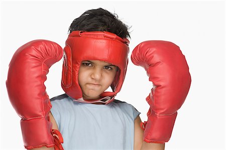 Portrait of a boy wearing boxing gloves and head protector Foto de stock - Sin royalties Premium, Código: 630-03481267