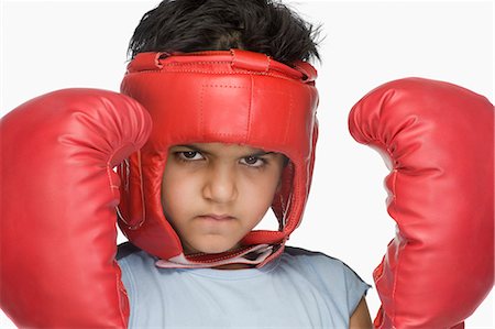 Portrait of a boy wearing boxing gloves and head protector Foto de stock - Sin royalties Premium, Código: 630-03481268