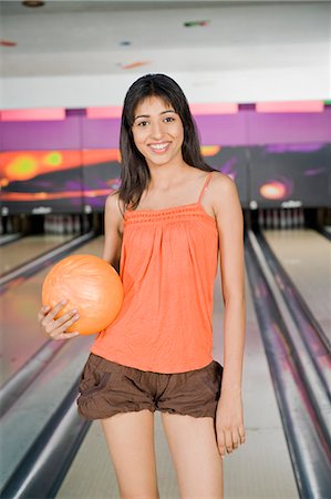 solid - Young woman holding a bowling ball in a bowling alley Stock Photo - Premium Royalty-Free, Code: 630-03481581