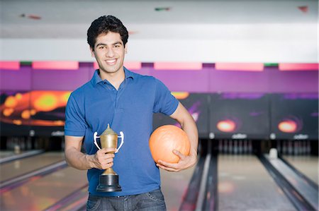 solid - Young man holding a bowling ball in a bowling alley Stock Photo - Premium Royalty-Free, Code: 630-03481619