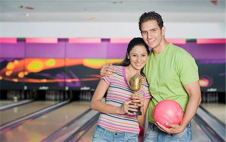 Young couple with a bowling ball and a trophy in a bowling alley Stock Photo - Premium Royalty-Free, Code: 630-03481623
