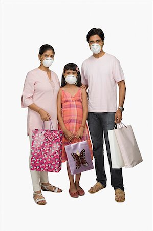 Portrait of a couple wearing flu mask and holding shopping bags Stock Photo - Premium Royalty-Free, Code: 630-03482015