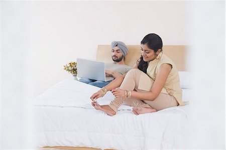 Woman painting toenails while her husband working on a laptop Stock Photo - Premium Royalty-Free, Code: 630-03482790