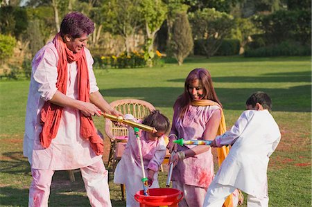 Family celebrating Holi with pichkaris Stock Photo - Premium Royalty-Free, Code: 630-03483026