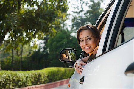 Woman sitting in a car and smiling Stock Photo - Premium Royalty-Free, Code: 630-03483097