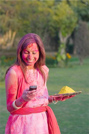 simsearch:400-05751461,k - Woman celebrating Holi and text messaging on a mobile phone Stock Photo - Premium Royalty-Free, Code: 630-03483124