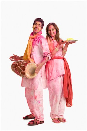 Couple celebrating Holi with colors and a drum Stock Photo - Premium Royalty-Free, Code: 630-03483130
