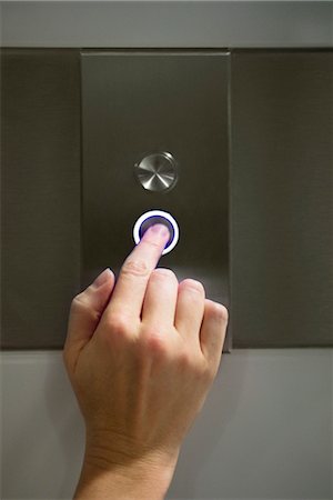 Woman's finger pushing elevator's down button Stock Photo - Premium Royalty-Free, Code: 632-05400969