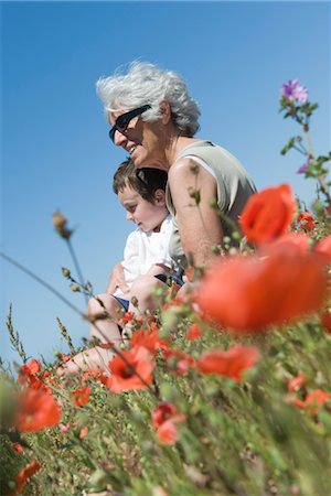 Grandmother and young grandson sitting together in field of poppies Stock Photo - Premium Royalty-Free, Code: 632-05401006