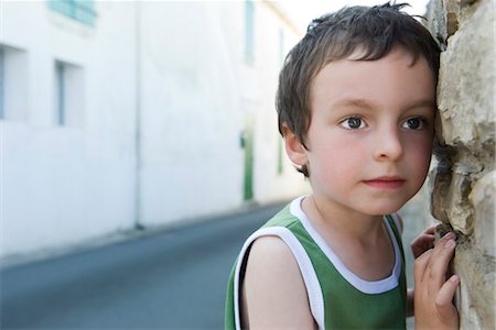 Little boy leaning against wall, portrait Stock Photo - Premium Royalty-Free, Code: 632-05401016