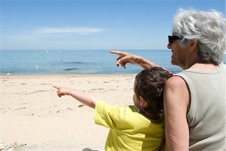 Grandmother and grandson sitting together on beach, pointing at sea Stock Photo - Premium Royalty-Free, Code: 632-05401165