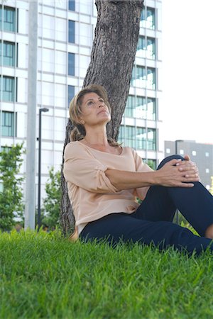 Woman sitting in grass looking up in thought Stock Photo - Premium Royalty-Free, Code: 632-05401193