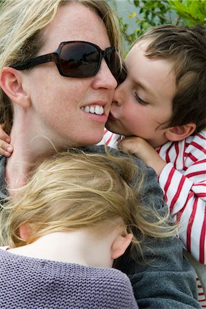 simsearch:632-05816381,k - Mother with two young children, son kissing her cheek Stock Photo - Premium Royalty-Free, Code: 632-05401253