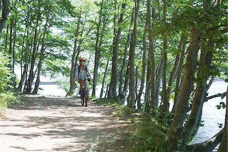 Woman riding bicycle in woods Stock Photo - Premium Royalty-Free, Code: 632-05553584