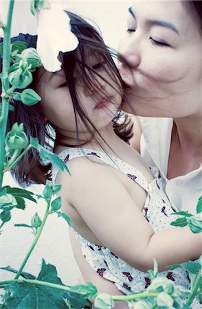 flower for mom asian - Mother kissing little girl's cheek Stock Photo - Premium Royalty-Free, Code: 632-05553590