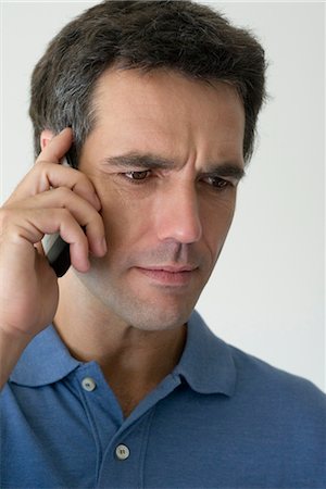 simsearch:632-05400935,k - Man using cell phone, looking down with concern Stock Photo - Premium Royalty-Free, Code: 632-05553664