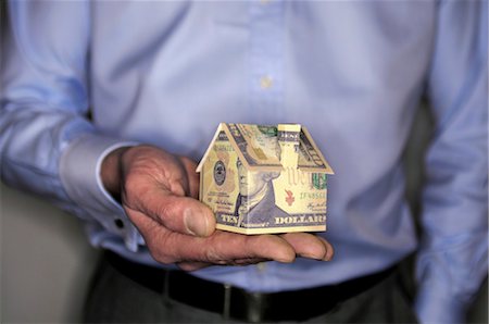 Man holding model house folded with dollar bill, mid section Stock Photo - Premium Royalty-Free, Code: 632-05553742