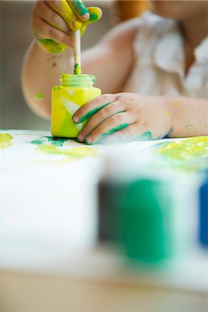 Child dipping paintbrush into jar of paint Stock Photo - Premium Royalty-Free, Code: 632-05604053