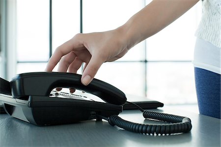 silhouette hand - Woman picking up telephone receiver, backlit, cropped Foto de stock - Sin royalties Premium, Código: 632-05604415