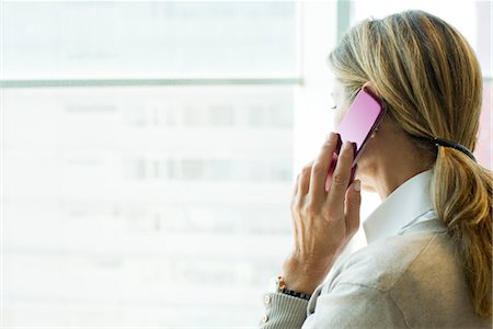 simsearch:632-05845617,k - Woman using cell phone, looking out window Stock Photo - Premium Royalty-Free, Code: 632-05759489