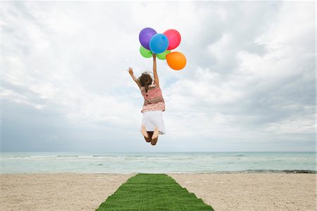 Girl jumping in air with bunch of colorful balloons, rear view Stock Photo - Premium Royalty-Free, Code: 632-05759675