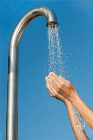 simsearch:632-05816631,k - Person holding hands under public shower Stock Photo - Premium Royalty-Free, Code: 632-05760053