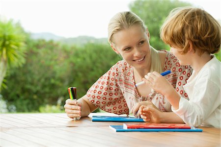 Mother and son sitting together with booklets and felt tip pens Stock Photo - Premium Royalty-Free, Code: 632-05760226