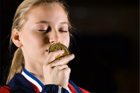 Female athlete kissing gold medal, portrait Stock Photo - Premium Royalty-Free, Code: 632-05760716