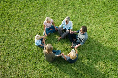 People sitting in circle on grass holding hands Stock Photo - Premium Royalty-Free, Code: 632-05816122