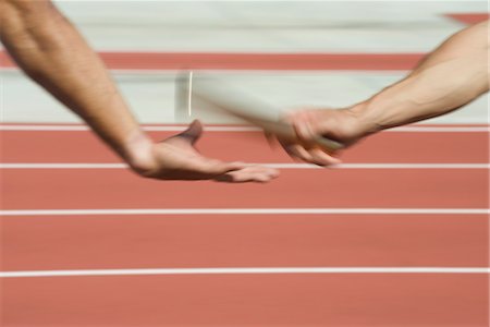 Runners exchanging baton in relay race, cropped Stock Photo - Premium Royalty-Free, Code: 632-05816598