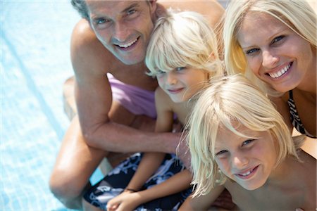 Family sitting together beside swimming pool, portrait Stock Photo - Premium Royalty-Free, Code: 632-05816873