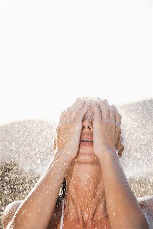 simsearch:632-05816631,k - Woman washing face under shower outdoors Stock Photo - Premium Royalty-Free, Code: 632-05845155