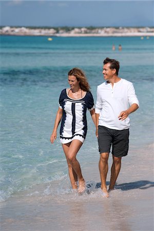 simsearch:632-05845211,k - Couple walking on beach holding hands, ankles deep in water Stock Photo - Premium Royalty-Free, Code: 632-05845164
