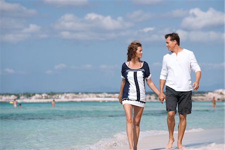 Couple marchant sur la plage main dans la main, portrait Photographie de stock - Premium Libres de Droits, Code: 632-05845202