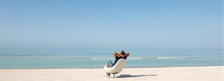 panorama - Man relaxing in chair on beach, rear view Stock Photo - Premium Royalty-Free, Code: 632-05845216