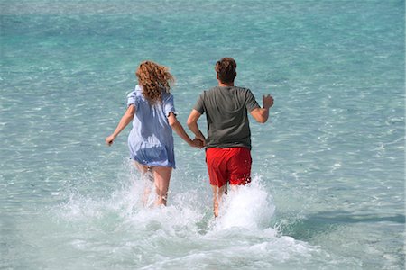 simsearch:632-05845211,k - Couple running into water holding hands, rear view Stock Photo - Premium Royalty-Free, Code: 632-05845271