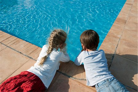 simsearch:614-06043612,k - Children lying beside swimming pool, gazing at water Stock Photo - Premium Royalty-Free, Code: 632-05845460